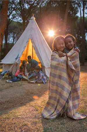 Children wrapped in blanket at campsite Stock Photo - Premium Royalty-Free, Code: 6113-07731137