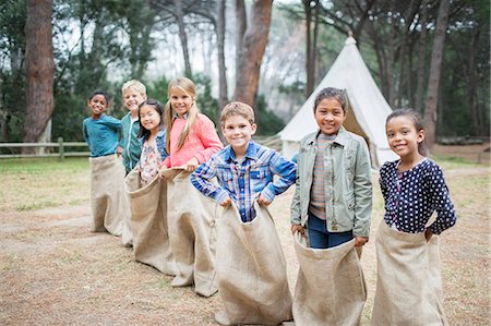 simsearch:6113-07731271,k - Children smiling at start of sack race Stock Photo - Premium Royalty-Free, Code: 6113-07731308