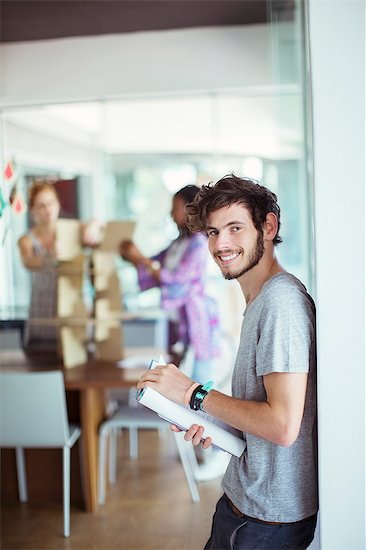 Man carrying book in office Stock Photo - Premium Royalty-Free, Image code: 6113-07731447