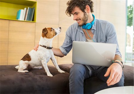 Man petting dog in office Photographie de stock - Premium Libres de Droits, Code: 6113-07731504