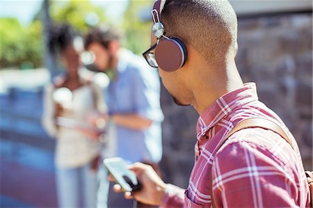 simsearch:6113-07542412,k - Man listening to mp3 player outdoors Stock Photo - Premium Royalty-Free, Code: 6113-07731506