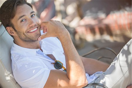 Smiling man relaxing outdoors Stock Photo - Premium Royalty-Free, Code: 6113-07731653