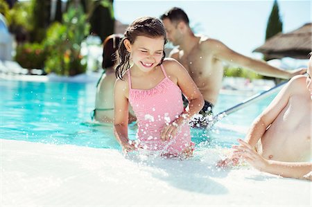 family water swimwear - Happy children splashing water in swimming pool Stock Photo - Premium Royalty-Free, Code: 6113-07808095