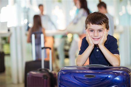 family suitcase vacations - Portrait of smiling boy leaning on suitcase in hotel lobby Stock Photo - Premium Royalty-Free, Code: 6113-07808167