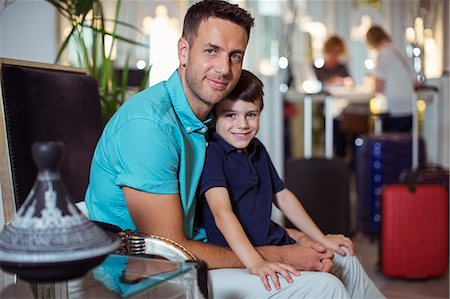 room - Portrait of man with son sitting in hotel lobby Photographie de stock - Premium Libres de Droits, Code: 6113-07808164