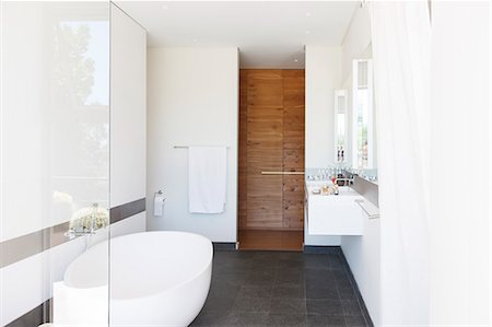 Modern bathroom interior with large bathtub and wooden door Foto de stock - Sin royalties Premium, Código: 6113-07808184