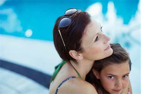 family fun at the pool - Pensive woman sitting by swimming pool with daughter Stock Photo - Premium Royalty-Free, Code: 6113-07808126