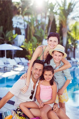 family sitting at pool - Portrait of happy family by swimming pool Stock Photo - Premium Royalty-Free, Code: 6113-07808129