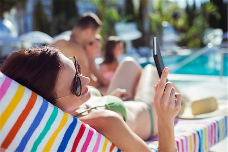 simsearch:6113-07808140,k - Woman sunbathing and texting by swimming pool Stock Photo - Premium Royalty-Free, Code: 6113-07808137