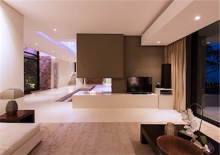 View of fireplace in luxurious living room during night Photographie de stock - Premium Libres de Droits, Code: 6113-07808247