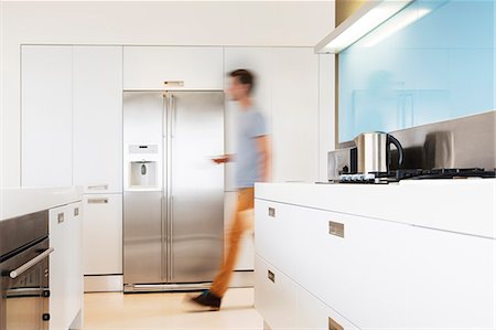 Man walking towards refrigerator in his modern kitchen Photographie de stock - Premium Libres de Droits, Code: 6113-07808204