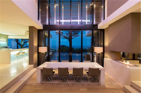 Modern dining room with fireplace and kitchen at night Foto de stock - Sin royalties Premium, Código: 6113-07808218