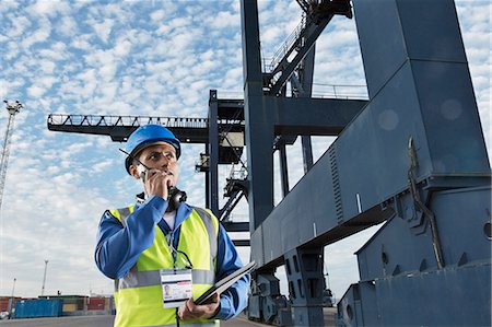 simsearch:632-05991735,k - Worker using walkie-talkie under cargo crane Stock Photo - Premium Royalty-Free, Code: 6113-07808347