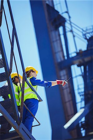 Low angle view of workers on cargo crane Stock Photo - Premium Royalty-Free, Code: 6113-07808344