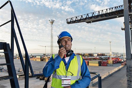 portuarios - Worker using walkie-talkie on cargo crane Foto de stock - Sin royalties Premium, Código: 6113-07808351