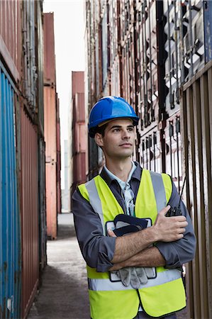 Worker standing between cargo containers Photographie de stock - Premium Libres de Droits, Code: 6113-07808385