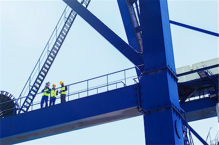 Low angle view of workers on cargo crane Stock Photo - Premium Royalty-Free, Code: 6113-07808389