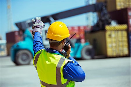 simsearch:6113-07565442,k - Worker using walkie-talkie near cargo containers Stock Photo - Premium Royalty-Free, Code: 6113-07808311
