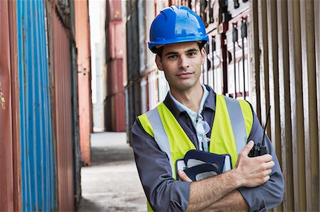 Worker standing between cargo containers Photographie de stock - Premium Libres de Droits, Code: 6113-07808314