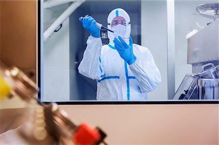 simsearch:6113-07808526,k - Scientist in clean suit pipetting sample into Petri dish in laboratory Stock Photo - Premium Royalty-Free, Code: 6113-07808446