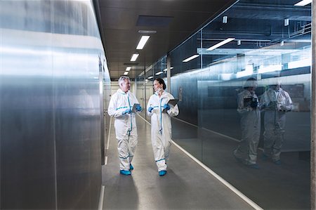 simsearch:6113-07808526,k - Scientists in clean suits walking in hallway Stock Photo - Premium Royalty-Free, Code: 6113-07808459