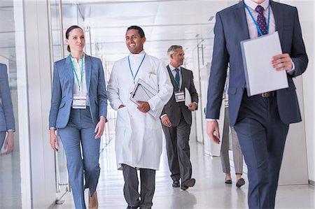 full body image of person in lab coat - Scientist and businesswoman talking in hallway Stock Photo - Premium Royalty-Free, Code: 6113-07808463