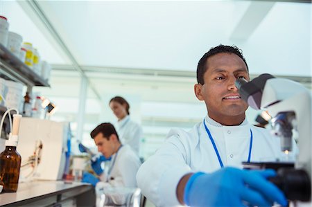 simsearch:6113-07808456,k - Scientist examining sample under microscope in laboratory Foto de stock - Sin royalties Premium, Código: 6113-07808480