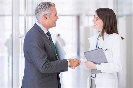 Scientist and businessman shaking hands in hallway Photographie de stock - Premium Libres de Droits, Code: 6113-07808488