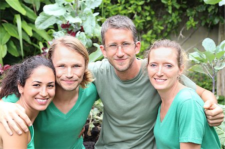 Portrait of four men and women wearing green t-shirts in garden Stock Photo - Premium Royalty-Free, Code: 6113-07808425