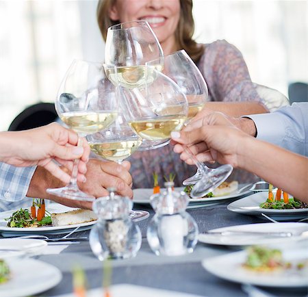 simsearch:6113-07808637,k - People toasting with white wine in restaurant Photographie de stock - Premium Libres de Droits, Code: 6113-07808599