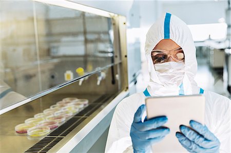 simsearch:6113-07808526,k - Scientist in clean suit using digital tablet in laboratory Stock Photo - Premium Royalty-Free, Code: 6113-07808509