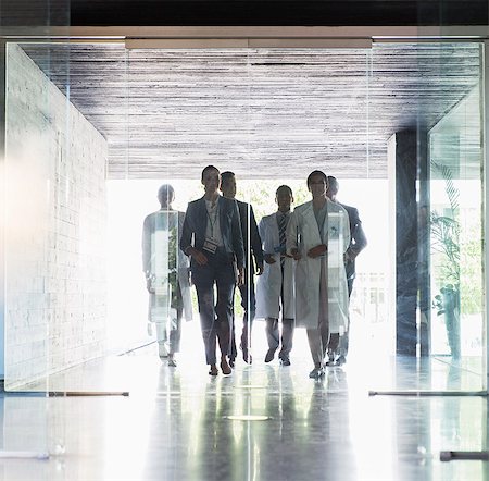 Scientists and business people approaching glass doors Stock Photo - Premium Royalty-Free, Code: 6113-07808518