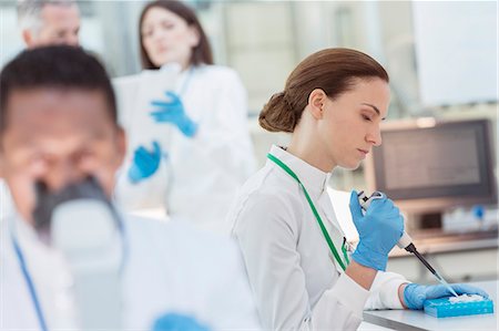 simsearch:6113-07808526,k - Scientist pipetting sample into tray in laboratory Stock Photo - Premium Royalty-Free, Code: 6113-07808526