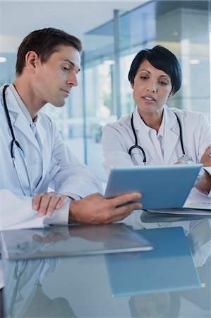 simsearch:6113-07808653,k - Doctors discussing patient's treatment at desk, using digital tablet Stock Photo - Premium Royalty-Free, Code: 6113-07808701