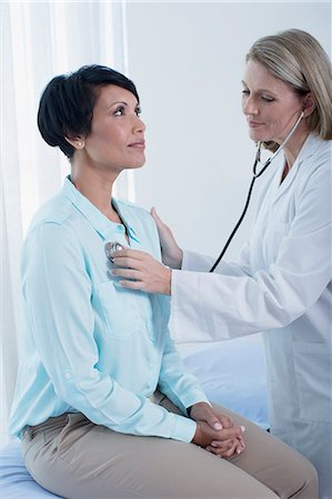 estetoscopio - Female doctor examining her patient with stethoscope in office Foto de stock - Sin royalties Premium, Código: 6113-07808711