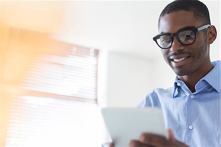 simsearch:6113-07808808,k - Portrait of young businessman wearing glasses using digital tablet in office Foto de stock - Royalty Free Premium, Número: 6113-07808840