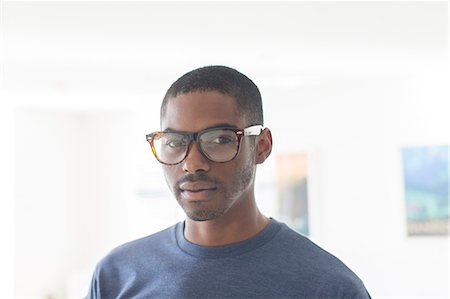 professional african portrait - Portrait of young businessman wearing glasses standing in office Stock Photo - Premium Royalty-Free, Code: 6113-07808835