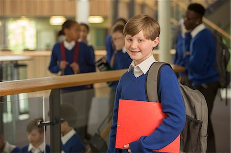 simsearch:6113-07961519,k - Portrait of elementary school boy wearing blue school uniform standing in school corridor Fotografie stock - Premium Royalty-Free, Codice: 6113-07961458