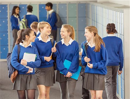 Cheerful female students wearing blue school uniforms walking in locker room Stock Photo - Premium Royalty-Free, Code: 6113-07961463