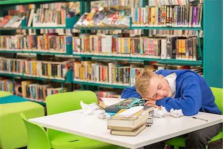 simsearch:6113-07961432,k - Exhausted student sleeping on table in library Foto de stock - Sin royalties Premium, Código: 6113-07961499