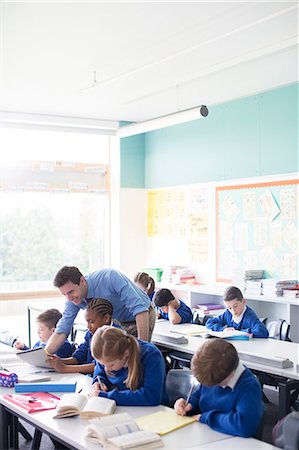 picture of student helping teacher - Teacher with his pupils in classroom Stock Photo - Premium Royalty-Free, Code: 6113-07961423