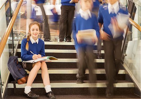 simsearch:6113-07961519,k - Portrait of smiling elementary school girl sitting on steps in school Fotografie stock - Premium Royalty-Free, Codice: 6113-07961501