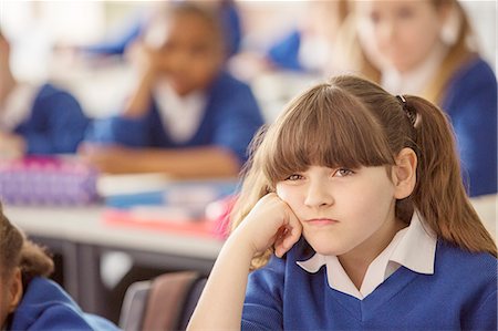 simsearch:6113-07961519,k - Elementary schoolgirl looking bored during lesson Fotografie stock - Premium Royalty-Free, Codice: 6113-07961517