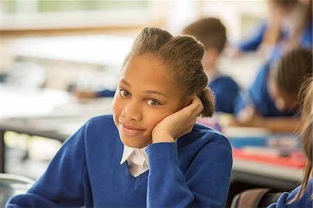 simsearch:6113-07961519,k - Portrait of smiling elementary school girl sitting bored in classroom Fotografie stock - Premium Royalty-Free, Codice: 6113-07961515