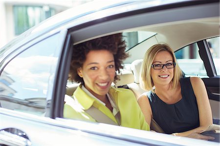 Businesswomen smiling in back seat of car Stock Photo - Premium Royalty-Free, Code: 6113-07961641