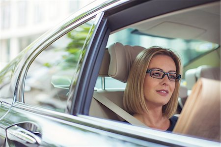 simsearch:6113-07961654,k - Businesswoman reading newspaper in back seat of car Stock Photo - Premium Royalty-Free, Code: 6113-07961656