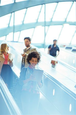 simsearch:6113-07961589,k - Woman using digital tablet on escalator Foto de stock - Sin royalties Premium, Código: 6113-07961667