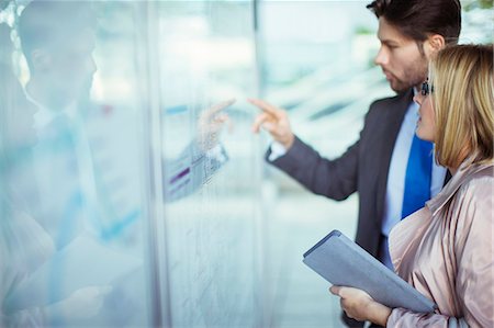 Business people reading transportation schedule at station Photographie de stock - Premium Libres de Droits, Code: 6113-07961664