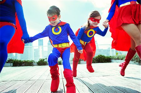 family fun outdoors adventure - Family of superheroes running on city rooftop Stock Photo - Premium Royalty-Free, Code: 6113-07961680