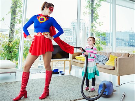 Daughter of superhero vacuuming her cape in living room Photographie de stock - Premium Libres de Droits, Code: 6113-07961692